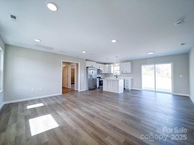 unfurnished living room with sink and wood-type flooring