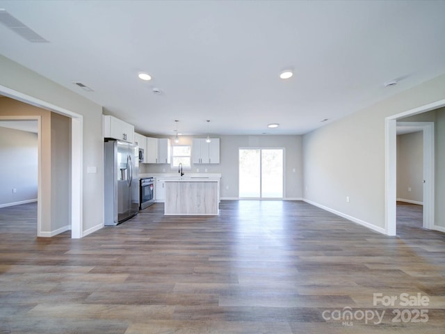 kitchen featuring light hardwood / wood-style flooring, sink, white cabinetry, pendant lighting, and stainless steel appliances