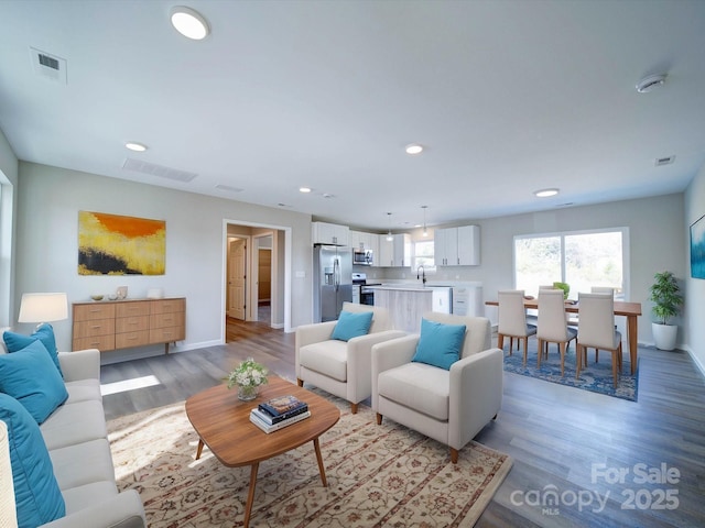 living room featuring sink and light hardwood / wood-style floors