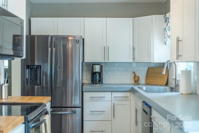 kitchen featuring tasteful backsplash, stainless steel fridge with ice dispenser, sink, and white cabinets