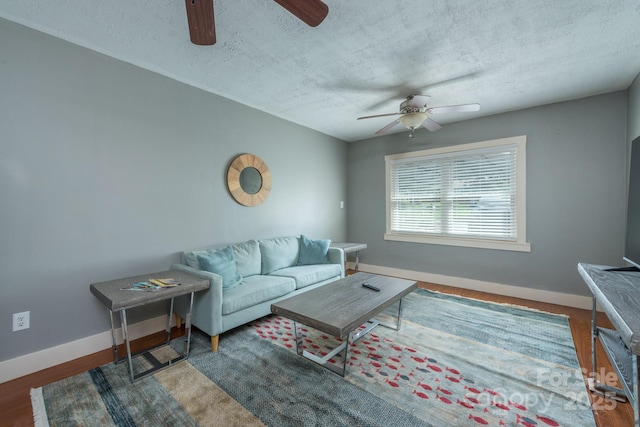 living room with ceiling fan and a textured ceiling