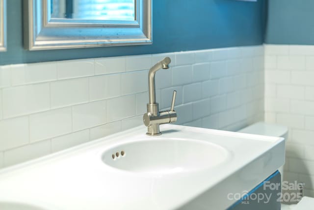 bathroom with vanity, tile walls, and toilet