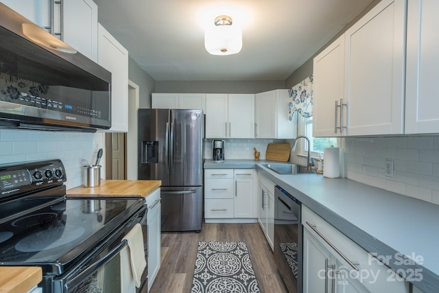 kitchen with sink, black appliances, and white cabinets