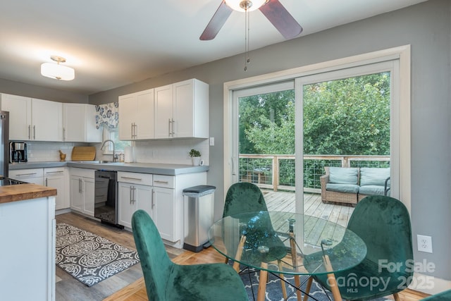 kitchen with a wealth of natural light, dishwasher, sink, and white cabinets