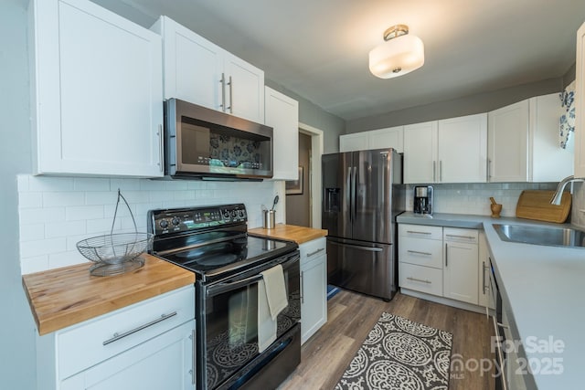 kitchen with white cabinetry, sink, wood counters, and stainless steel appliances