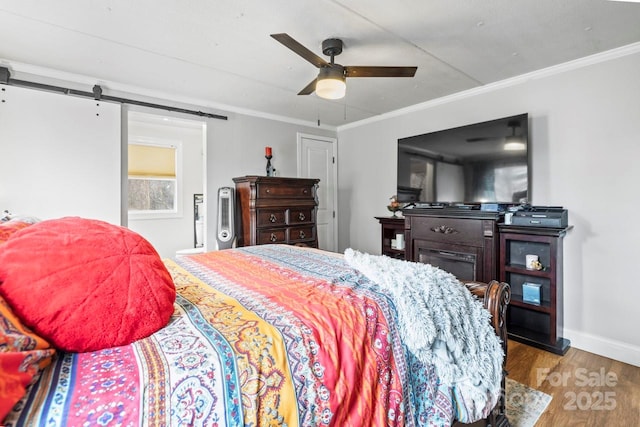 bedroom featuring crown molding, a barn door, light wood-type flooring, and ceiling fan