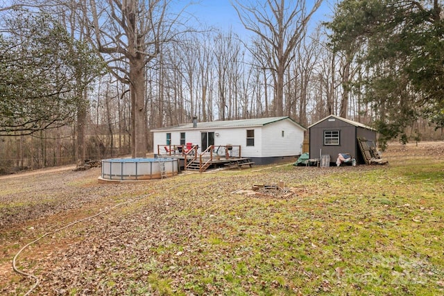 back of property featuring a storage unit and a swimming pool side deck