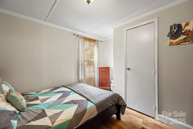 bedroom with hardwood / wood-style flooring and ornamental molding