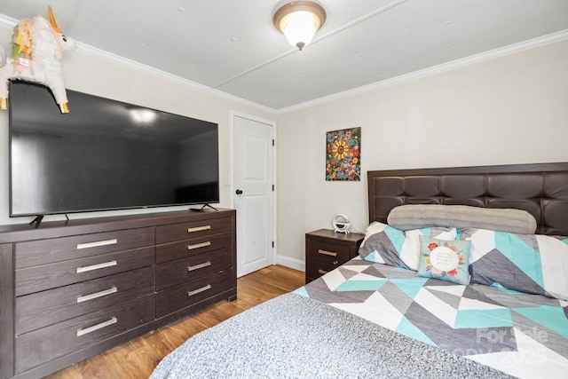 bedroom featuring crown molding and light hardwood / wood-style flooring