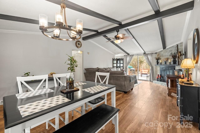 dining space with hardwood / wood-style floors, vaulted ceiling with beams, and ceiling fan with notable chandelier