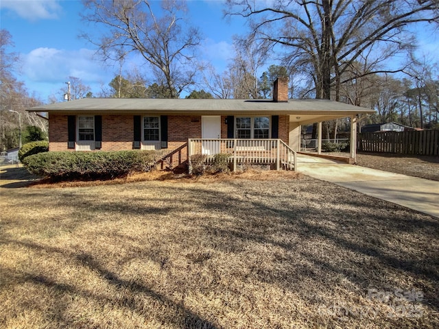 ranch-style home featuring a front lawn and a carport