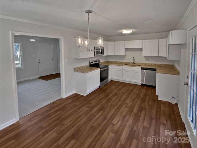 kitchen featuring pendant lighting, appliances with stainless steel finishes, white cabinetry, sink, and crown molding