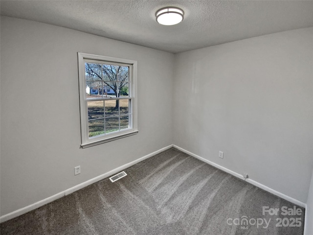 carpeted empty room with a textured ceiling