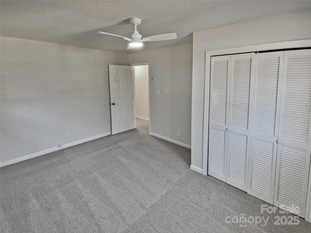 unfurnished bedroom with a closet, ceiling fan, a textured ceiling, and light carpet