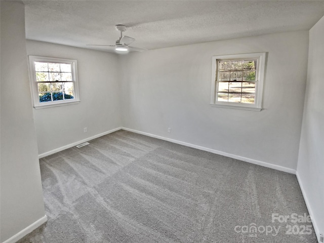 carpeted empty room featuring ceiling fan and a textured ceiling