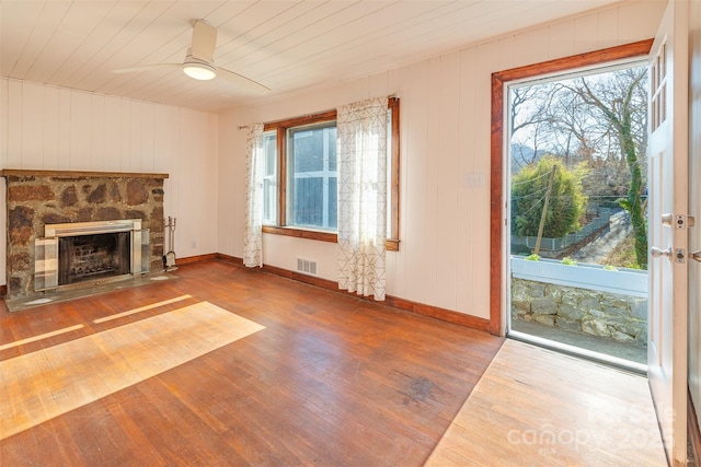 unfurnished living room with hardwood / wood-style flooring, a fireplace, wood ceiling, visible vents, and a ceiling fan