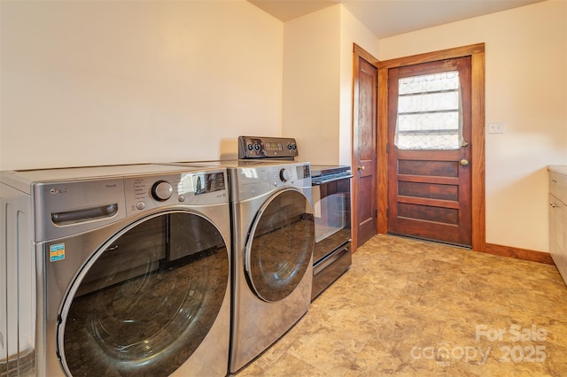 laundry area with laundry area, washer and clothes dryer, and baseboards