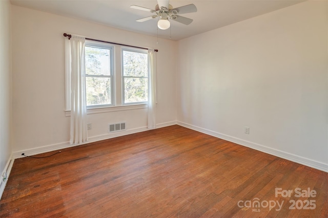 unfurnished room featuring wood-type flooring, visible vents, ceiling fan, and baseboards