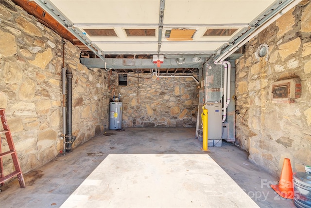 garage featuring heating unit and electric water heater