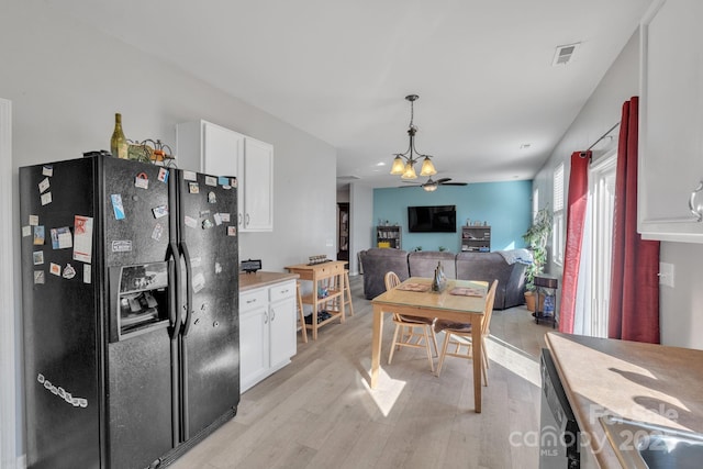 kitchen with ceiling fan with notable chandelier, white cabinetry, black appliances, decorative light fixtures, and light wood-type flooring