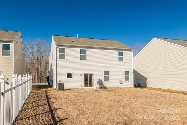 rear view of property featuring a yard and central AC