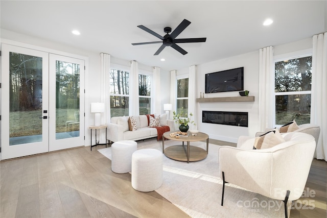 living room featuring light hardwood / wood-style floors, ceiling fan, and french doors