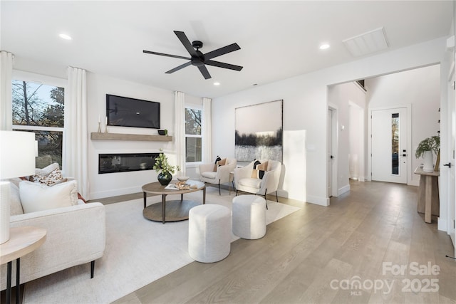 living room featuring ceiling fan and light hardwood / wood-style flooring