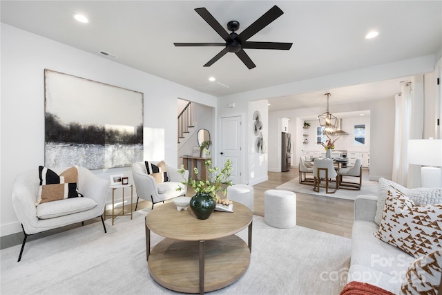 living room with ceiling fan and light hardwood / wood-style flooring