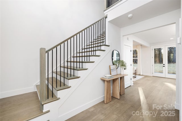 stairway featuring wood-type flooring and french doors