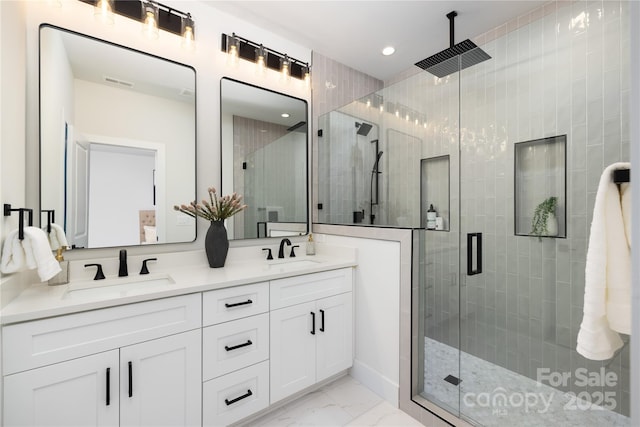 bathroom featuring a shower with shower door and vanity