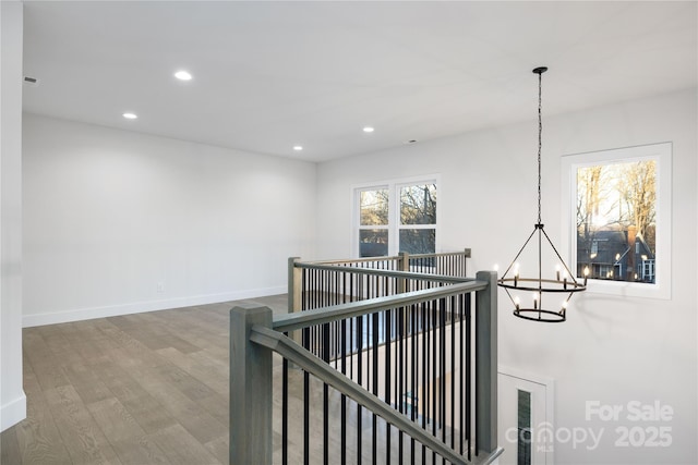 hall with hardwood / wood-style floors and a chandelier