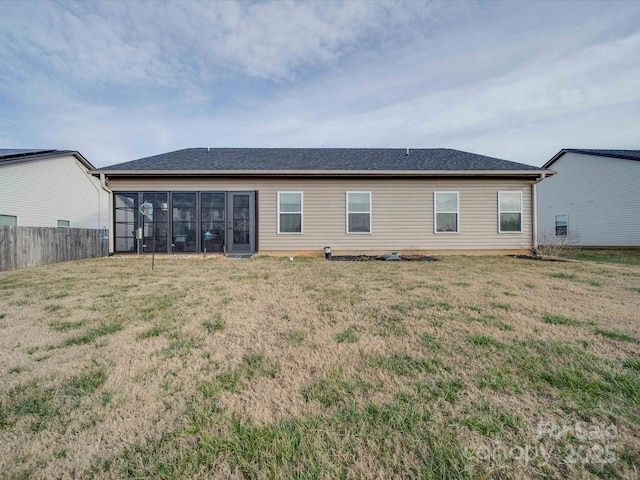 rear view of property with a yard and a sunroom