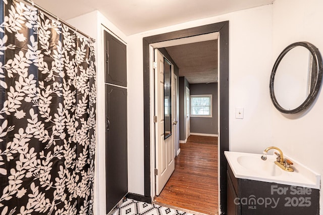 bathroom with vanity, wood-type flooring, and curtained shower