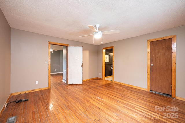 spare room with ceiling fan, a textured ceiling, and light hardwood / wood-style floors