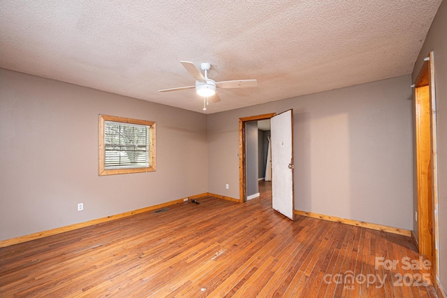 spare room with a textured ceiling, ceiling fan, and light hardwood / wood-style flooring