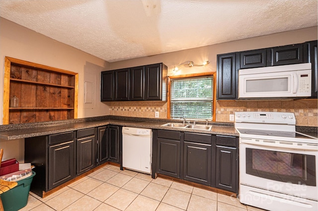 kitchen featuring white appliances, a textured ceiling, tasteful backsplash, sink, and light tile patterned floors