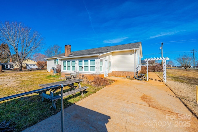 rear view of house featuring a yard and a pergola