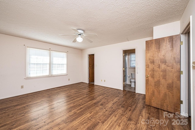 empty room featuring dark hardwood / wood-style floors, a textured ceiling, and ceiling fan