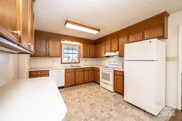 kitchen with white appliances, sink, and a textured ceiling