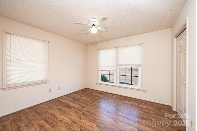 unfurnished bedroom with ceiling fan, dark wood-type flooring, a closet, and a textured ceiling