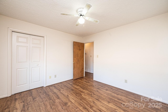 unfurnished bedroom with wood-type flooring, ceiling fan, a textured ceiling, and a closet