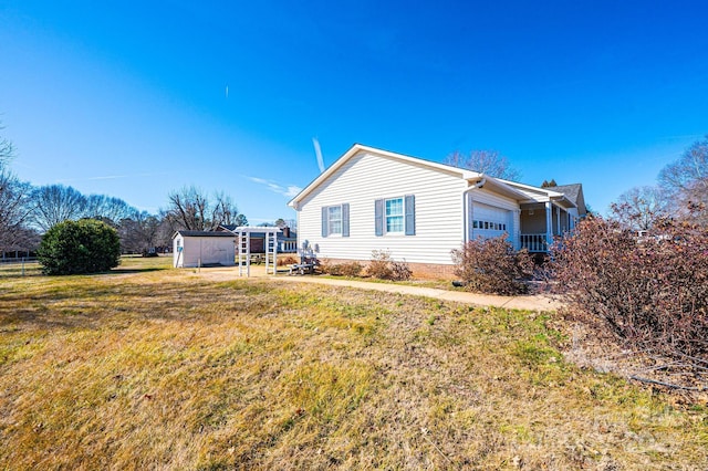 view of side of property with a garage, a storage unit, and a lawn