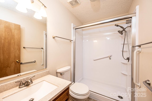 bathroom featuring vanity, toilet, a textured ceiling, and a shower