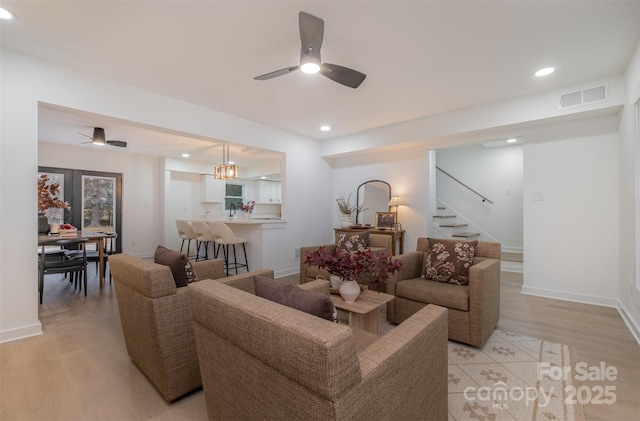 living room featuring ceiling fan and light hardwood / wood-style flooring