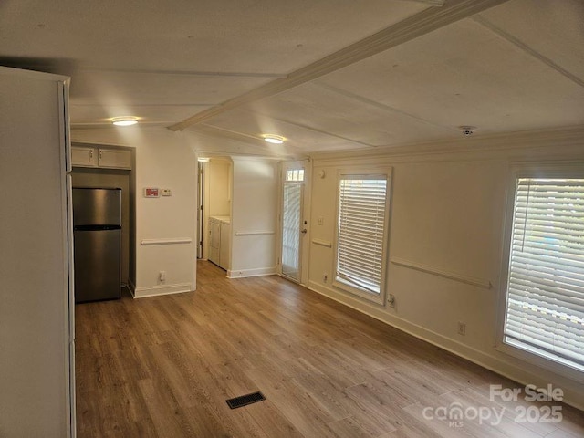 interior space featuring wood-type flooring and vaulted ceiling with beams