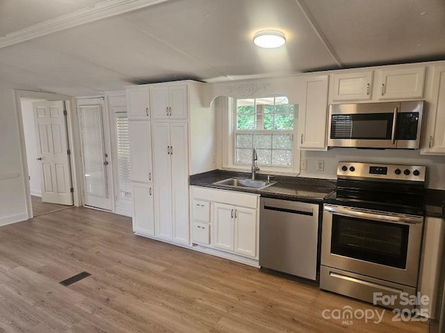 kitchen featuring light hardwood / wood-style floors, sink, white cabinetry, and appliances with stainless steel finishes