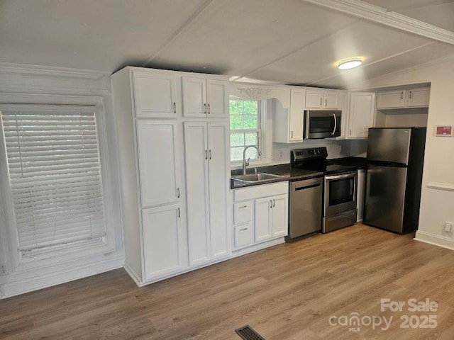 kitchen with sink, light wood-type flooring, white cabinetry, and appliances with stainless steel finishes