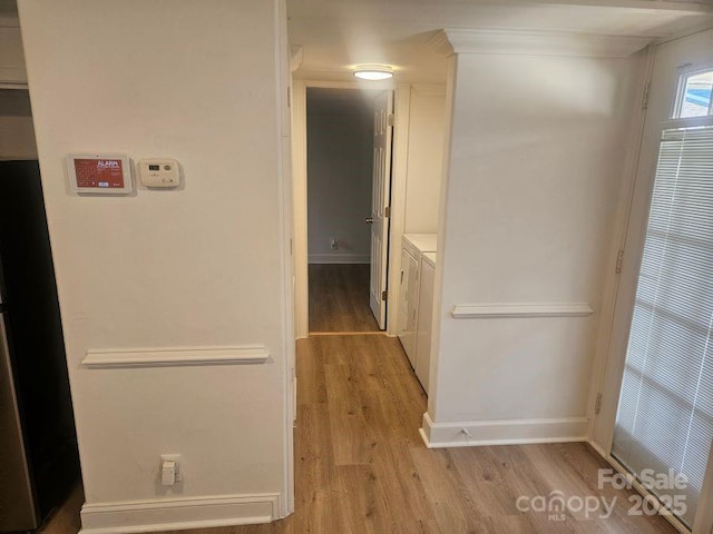 corridor featuring independent washer and dryer and light wood-type flooring