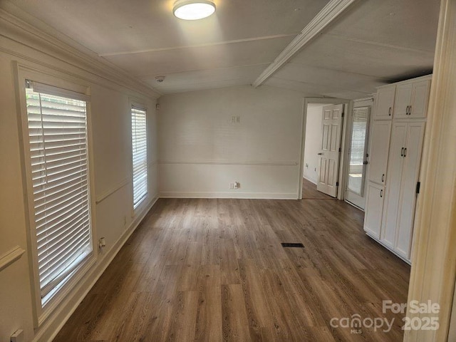 interior space with dark hardwood / wood-style floors and vaulted ceiling with beams