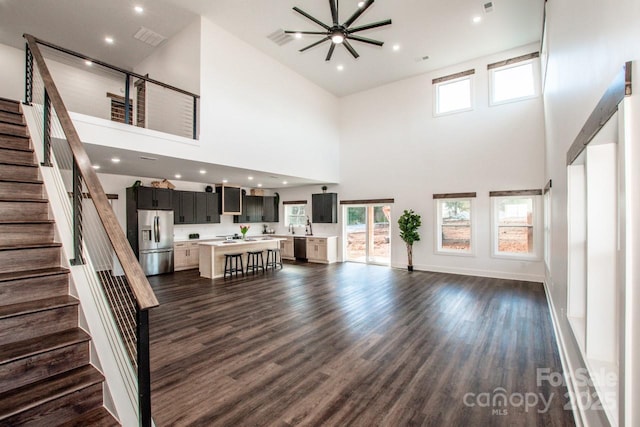 unfurnished living room featuring dark wood-type flooring and a high ceiling